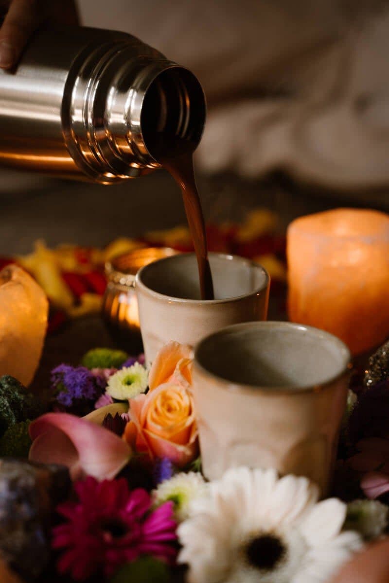Ceremoniële cacao wordt geschonken tussen bloemen en kaarsen